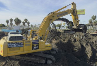 A large yellow excavator sitting on top of a pile of dirt